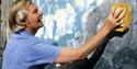 Artist Tony Hart using a sponge to create a large-scale artwork
