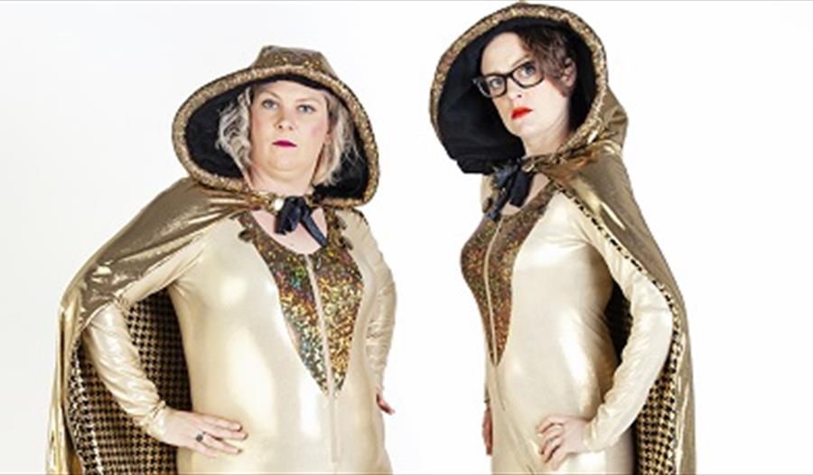 Two ladies dressed in gold cloaks
