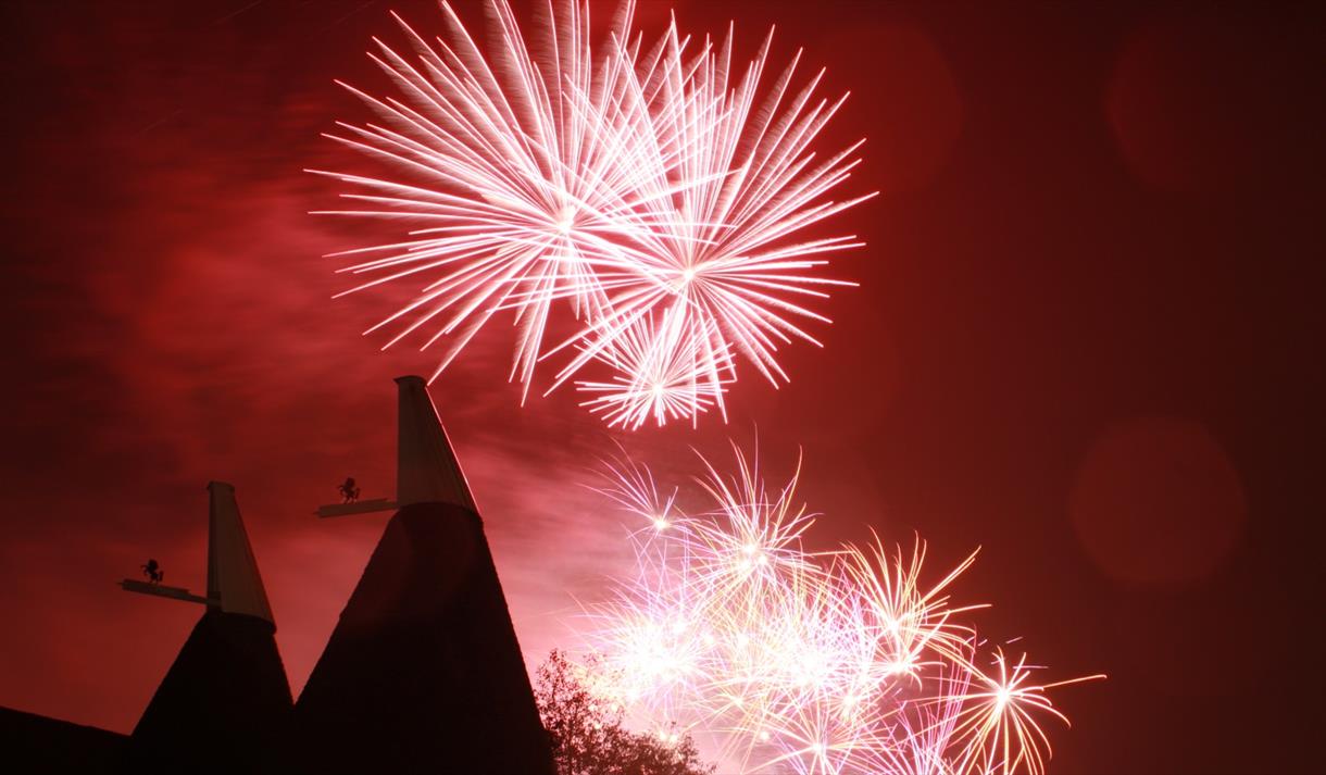 Fireworks and oast house in the night sky