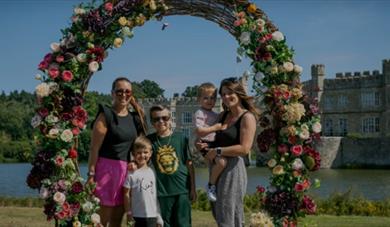 Family standing inside a large flower design ring with castle behind