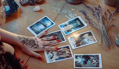 Hand with tarot cards, lavender and crystals