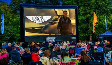 Outdoor cinema showing Top Gun: Maverick with crowd watching