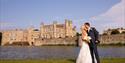 Wedding couple pose in front of Leeds Castle