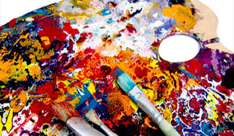 artist palate with lots of different colour paints and brushes