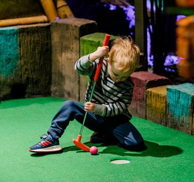 Child playing minigolf at Treetop Adventure Golf