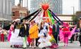 Group of people on Parade with the sign 'Queerly  Beloved'