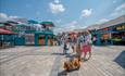 Group of friends walking their dog at the Cheshire Oaks food and drink area