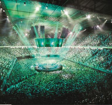 full stadium with green lighting and central circular stage