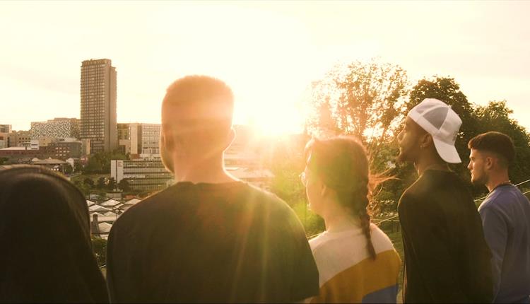Five young people looking towards the city in a sunshine Five young people looking towards the city in a sunshine
