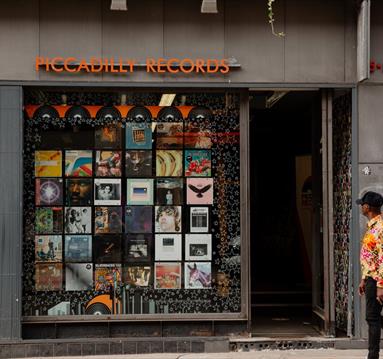 Man walking past Piccadilly Records in Manchester