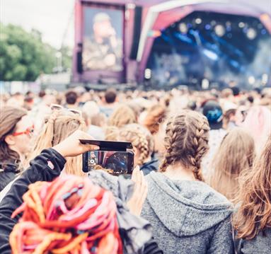 Crowd in front of a stage taking photos