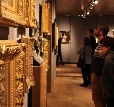 Patrons looking at art in gold frames