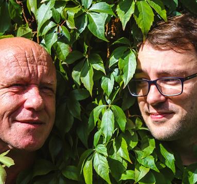 The Orb band members hiding in a hedge