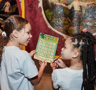 Two girl holding banner bingo card