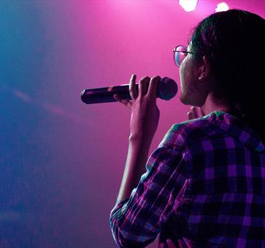 Woman onstage holding a microphone