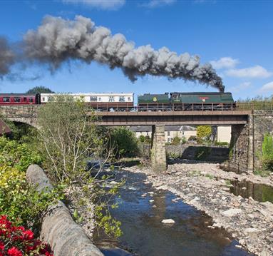 East Lancashire Railway train travelling over countryside bridge