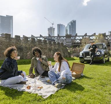 Group of friends enjoying afternoon tea outside on a Manchester Taxi Tour