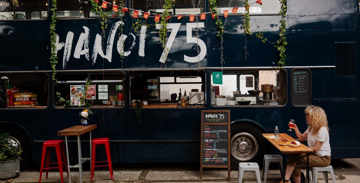 Person enjoying food outside a converted bus