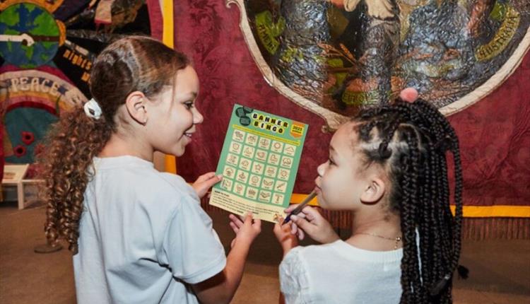 Two girl holding banner bingo card
