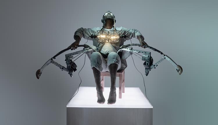 Benji Reid sat in a chair in a dystopian costume