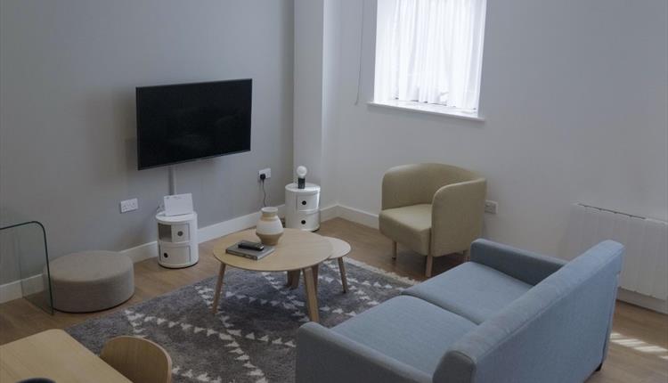 Living area with dining table and TV in the room at Stay Cove hotel, Piccadilly, Manchester