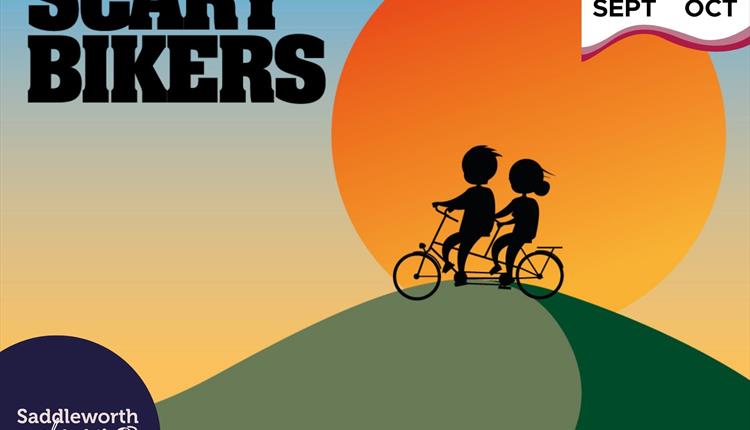 Silhouette of two bikers going over a hill