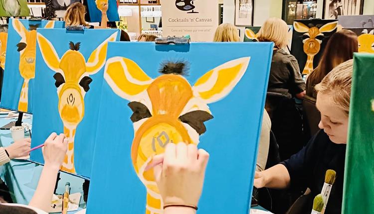 Guests painting a giraffe at Cocktails n Canvas event