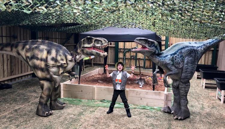 Child next to two dinosaurs