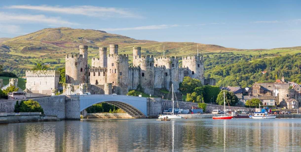 Conwy Castle with body of water and hills in the background