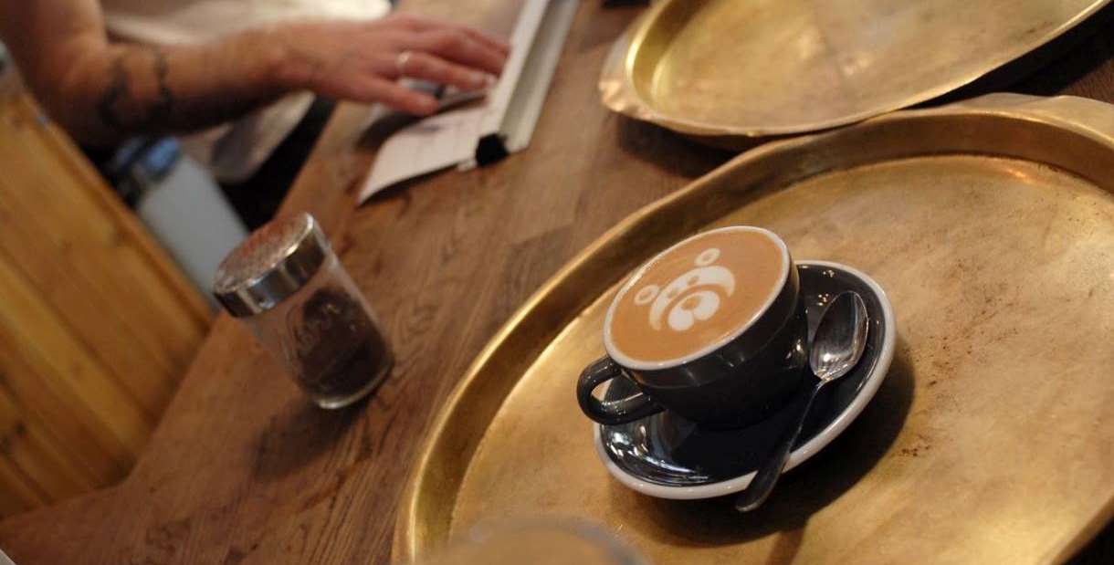 Coffee in a cup and saucer with teddy bear coffee art.