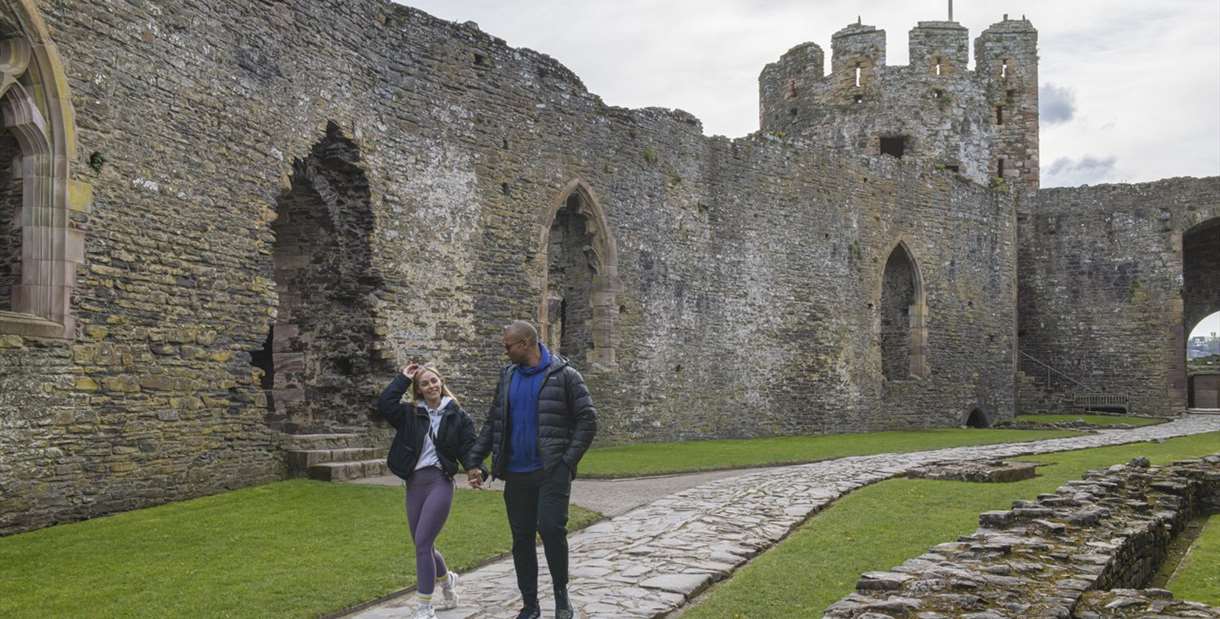 Couple walking in front of Welsh castle
