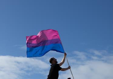 A person carrying a bi-sexual coloured flag
