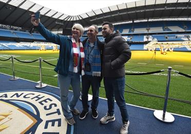 Fans on a stadium tour taking a selfie inside the Etihad Stadium