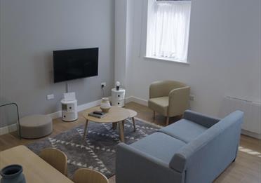 Living area with dining table and TV in the room at Stay Cove hotel, Piccadilly, Manchester