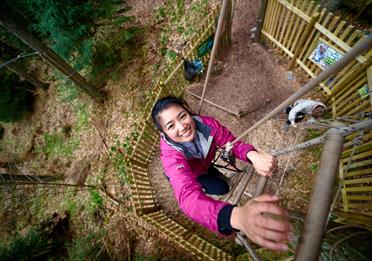 Person climbing ladders at Go Ape Rivington