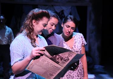 Three girls reading newspaper