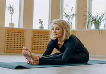 Photo of a Woman Wearing Activewear Stretching
