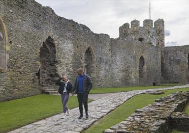 Couple walking in front of Welsh castle