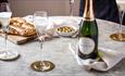 Glasses and bottle of champagne on a table with food