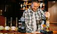 Coronation Street Experience man pouring a pint in The Rover's Return pub
