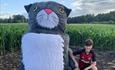child next to a large size Mog