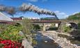 East Lancashire Railway train travelling over countryside bridge