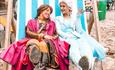 Giant deck chair with two women dressed as disney princesses sat in it