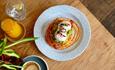 Freshly prepared food on a plate with fresh juice and a coffee