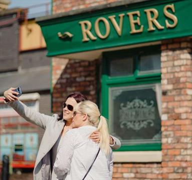 Two people taking a selfie at Coronation Street The Tour