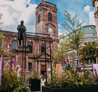 Urban garden by a statue in St Ann's Square, Manchester