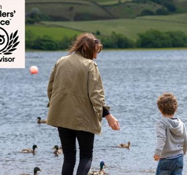 A mother and child feeding ducks at Hollingworth Lake. 
