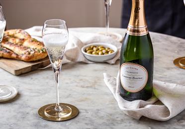 Glasses and bottle of champagne on a table with food