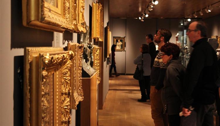 Patrons looking at art in gold frames