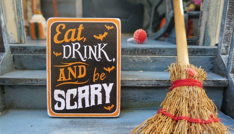 Eat drink and be scary sign with wooden broom